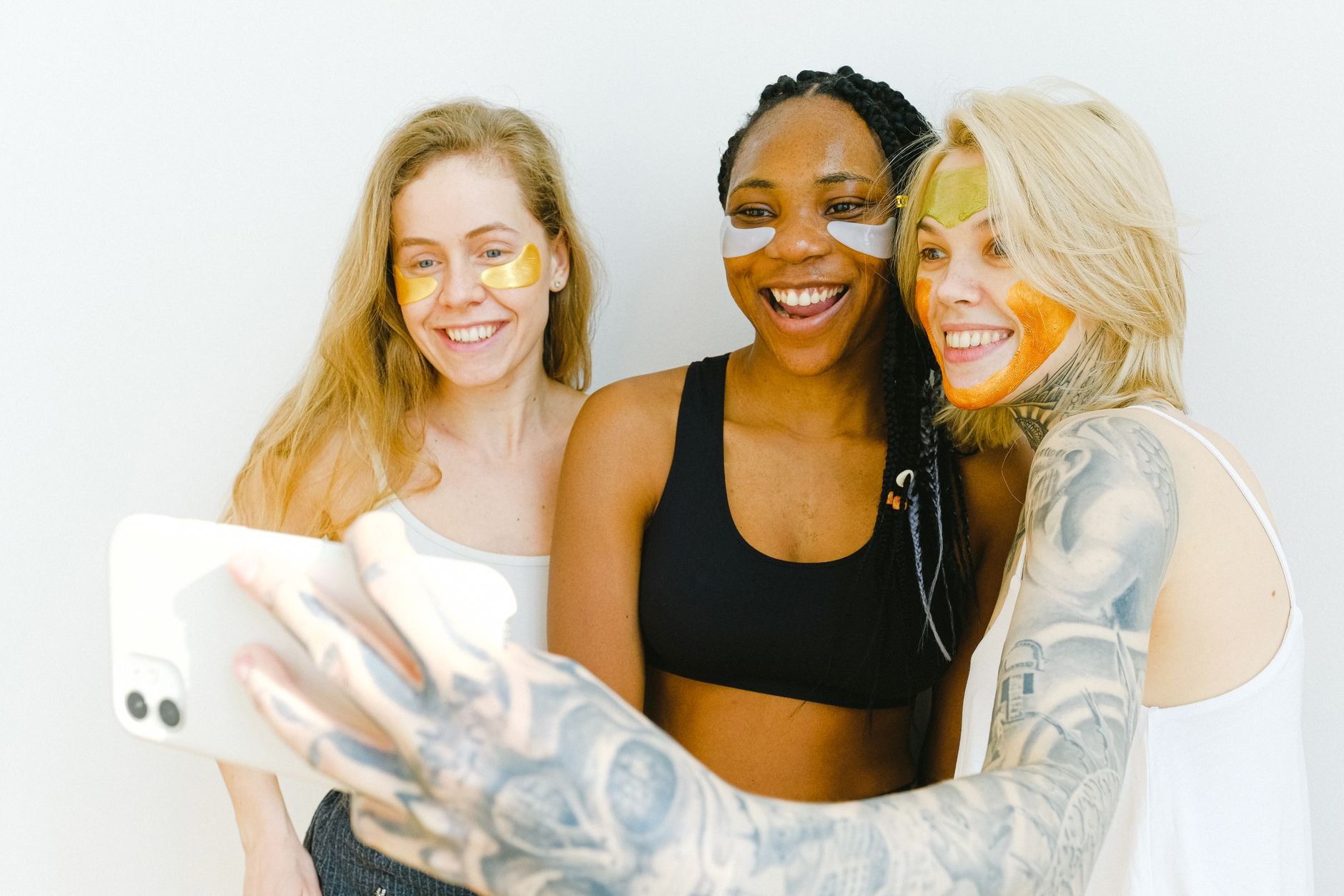 Group of happy women laughing while having fun and taking selfies together